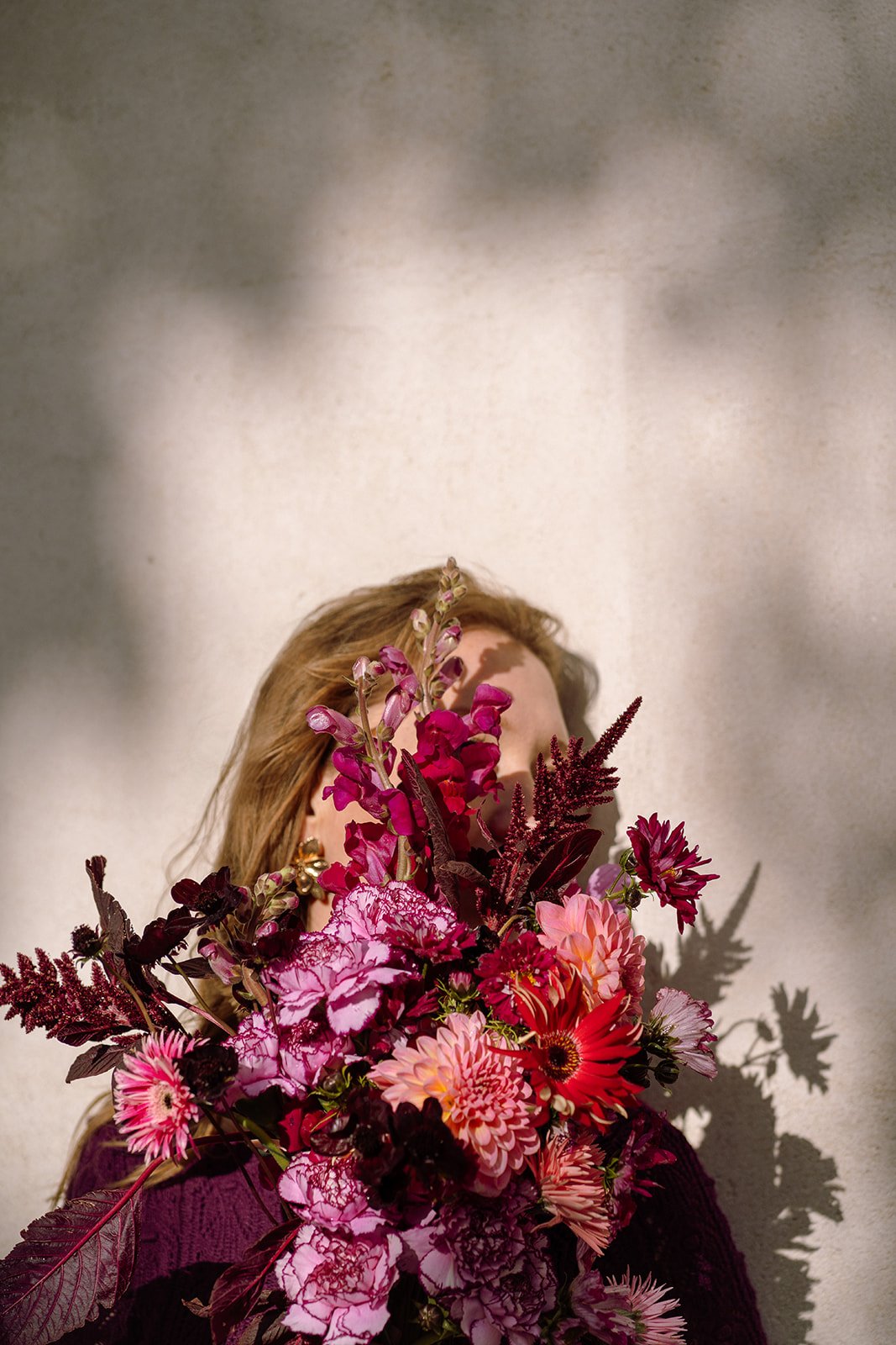 Visage caché par un bouquet de fleurs avec jeu d'ombre et de lumière. Photo Motoucourt